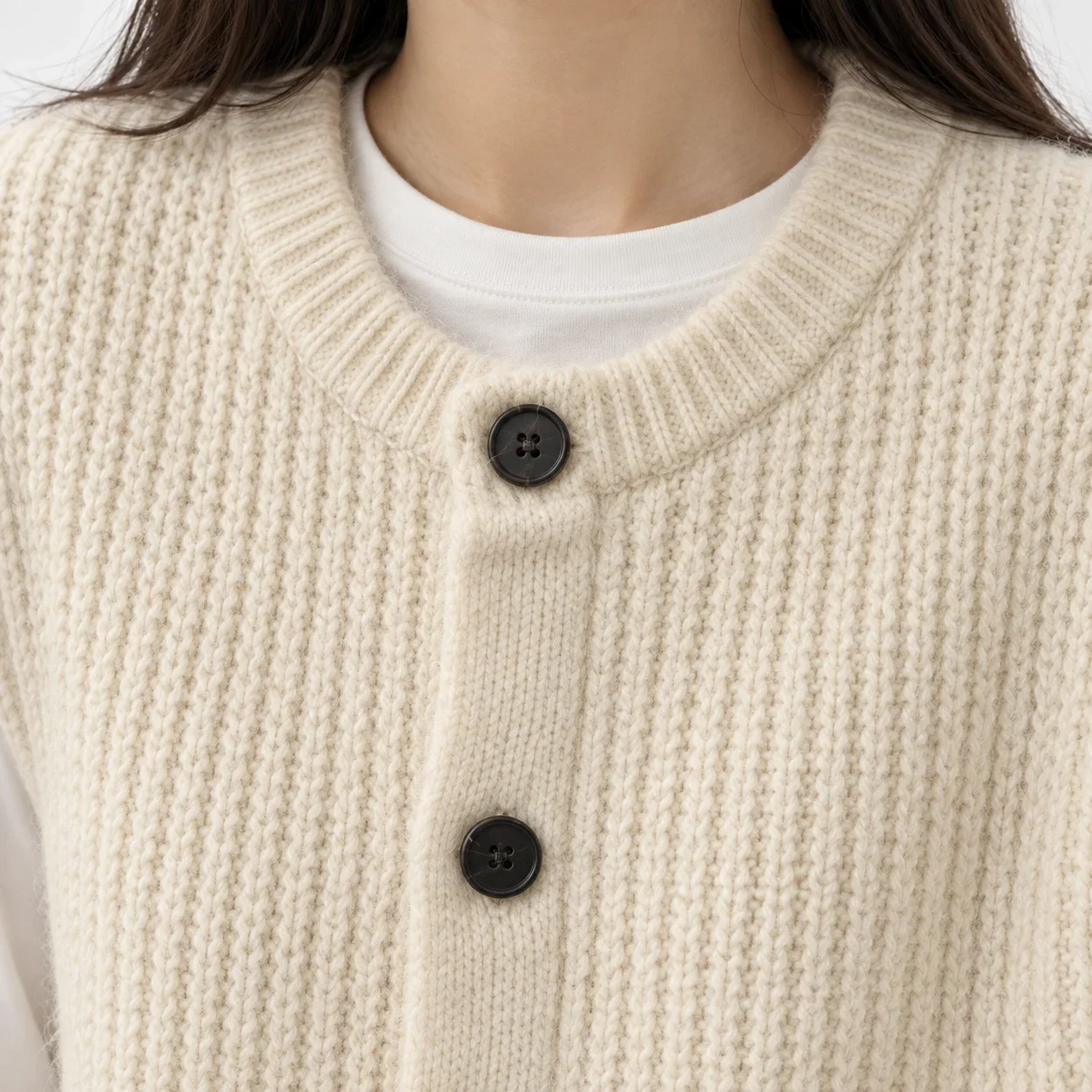 Close view of the Adeline vest knit and dark button construction
